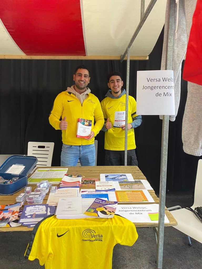 Mert (links) op een informatiemarkt voor jongeren.
